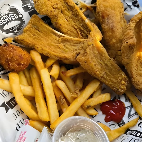 Fried fish, french fries, a hushpuppy, ketchup, and tartar sauce from Delta Fish Market.